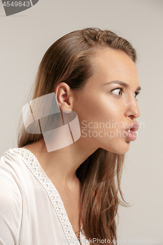 Image of Portrait of an angry woman looking at camera isolated on a gray background