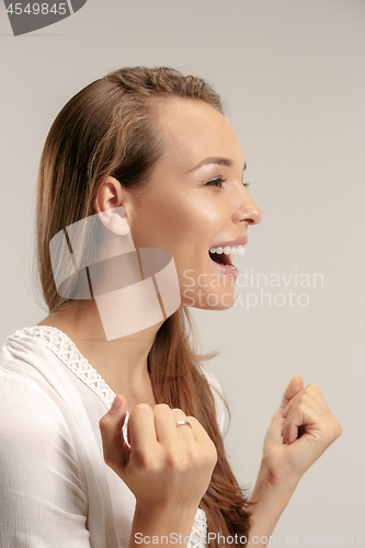 Image of The happy business woman standing and smiling against pastel background.
