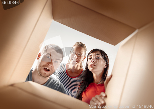 Image of The people unpacking and opening carton box and looking inside