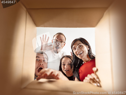 Image of The people unpacking and opening carton box and looking inside