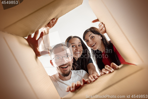 Image of The people unpacking and opening carton box and looking inside