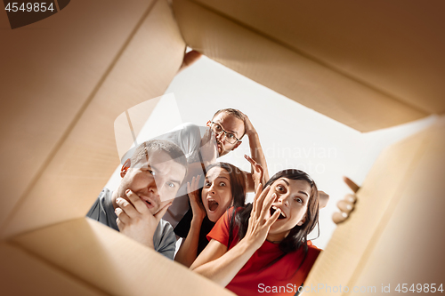 Image of The people unpacking and opening carton box and looking inside