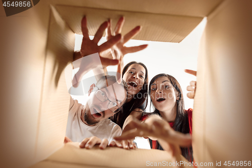 Image of The people unpacking and opening carton box and looking inside