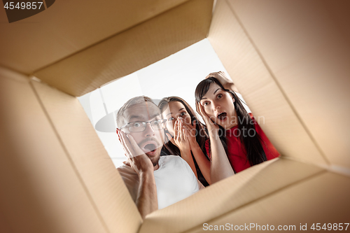 Image of The people unpacking and opening carton box and looking inside