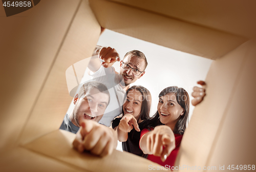 Image of The people unpacking and opening carton box and looking inside