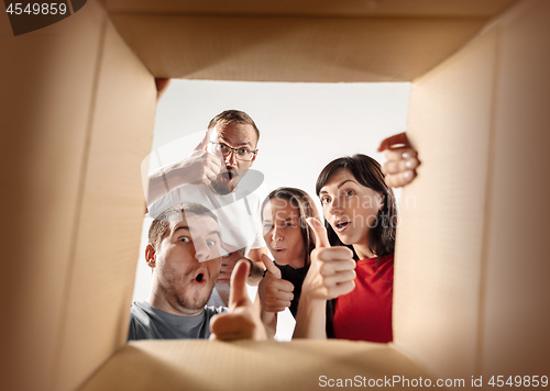 Image of The people unpacking and opening carton box and looking inside