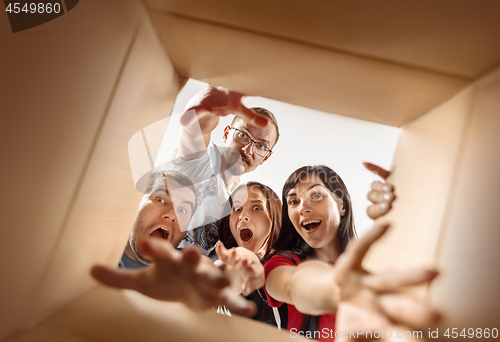 Image of The people unpacking and opening carton box and looking inside