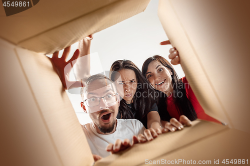 Image of The people unpacking and opening carton box and looking inside