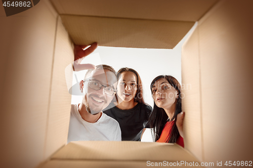 Image of The people unpacking and opening carton box and looking inside