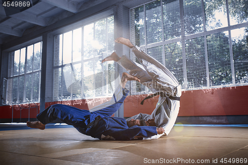 Image of Two judo fighters showing technical skill while practicing martial arts in a fight club