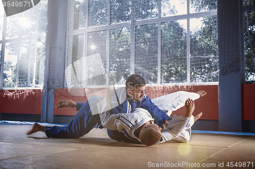 Image of Two judo fighters showing technical skill while practicing martial arts in a fight club