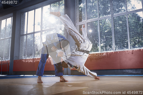 Image of Two judo fighters showing technical skill while practicing martial arts in a fight club