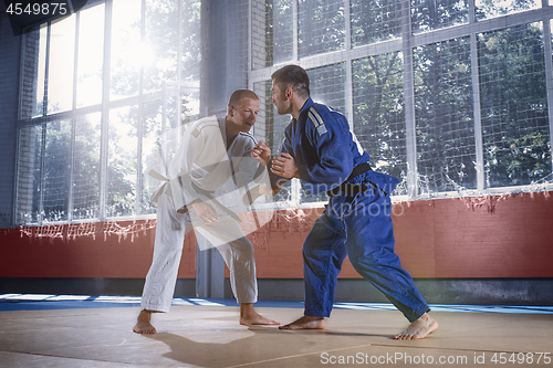 Image of Two judo fighters showing technical skill while practicing martial arts in a fight club