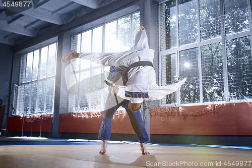 Image of Two judo fighters showing technical skill while practicing martial arts in a fight club