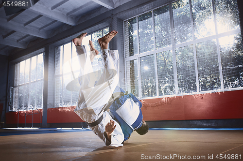 Image of Two judo fighters showing technical skill while practicing martial arts in a fight club