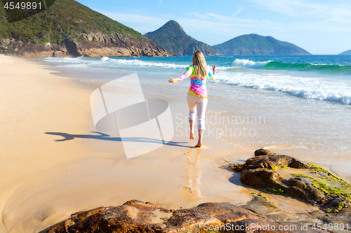 Image of Woman running along the beach