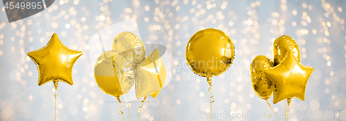 Image of many metallic gold helium balloons on white