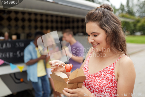 Image of happy woman with wok and friends at food truck