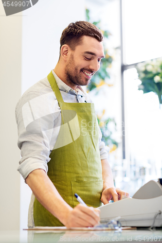 Image of florist man or seller at flower shop counter