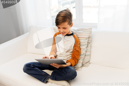 Image of smiling boy with tablet pc computer at home