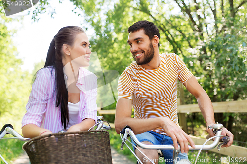 Image of happy couple with bicycles at summer park