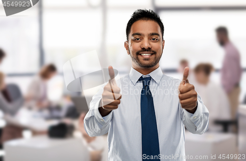 Image of indian businessman showing thumbs up at office