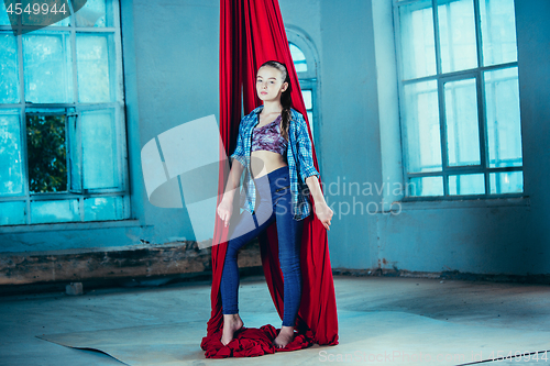 Image of Graceful gymnast resting after performing aerial exercise at loft