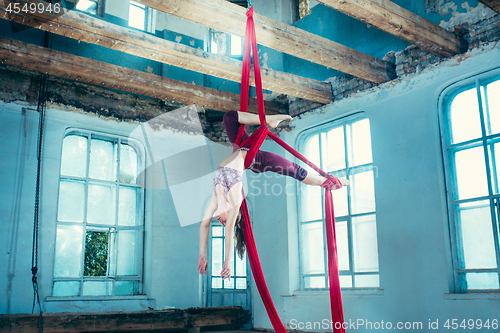 Image of Graceful gymnast performing aerial exercise