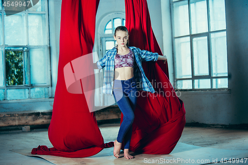 Image of Graceful gymnast resting after performing aerial exercise at loft