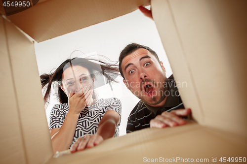 Image of The couple unpacking and opening carton box and looking inside