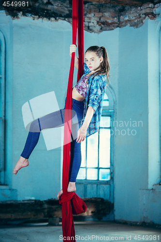 Image of Graceful gymnast performing aerial exercise at loft