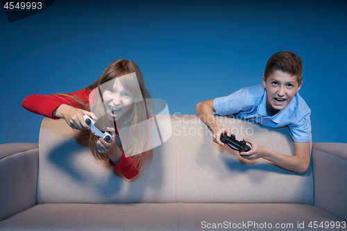 Image of Computer game competition. Gaming concept. Excited girl playing video game with joystick