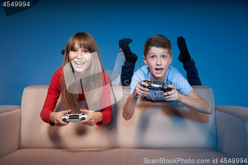 Image of Computer game competition. Gaming concept. Excited girl playing video game with joystick