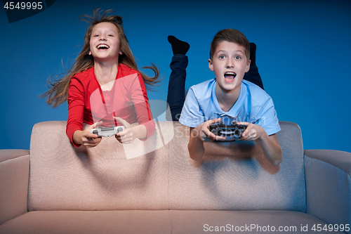 Image of Computer game competition. Gaming concept. Excited girl playing video game with joystick