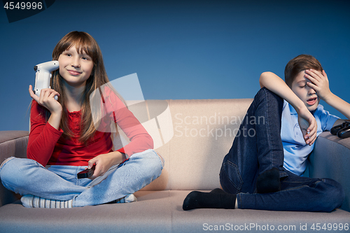 Image of Gaming concept. Tired children on sofa with game joysticks