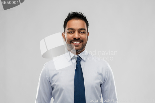 Image of indian businessman in shirt with tie over grey