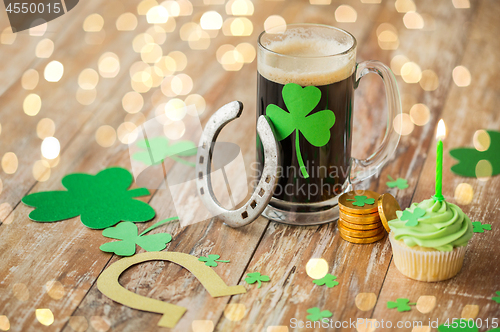 Image of glass of beer, horseshoe, green cupcake and coins