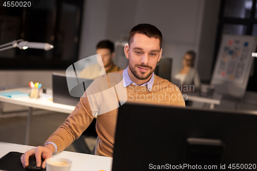 Image of man with computer working late at night office