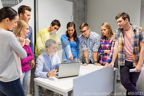 Image of students and teacher with laptop at school