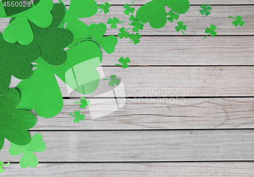 Image of green paper shamrocks on wooden background