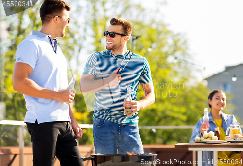 Image of happy friends having bbq party on rooftop