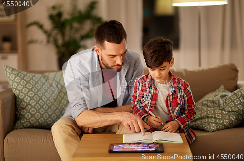 Image of father and son doing homework together