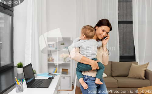 Image of mother with baby calling on smartphone at home