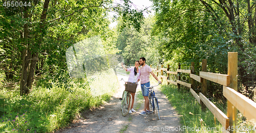 Image of couple with bicycles taking selfie by smartphone