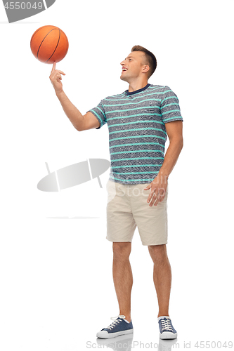 Image of smiling young man spinning ball on finger