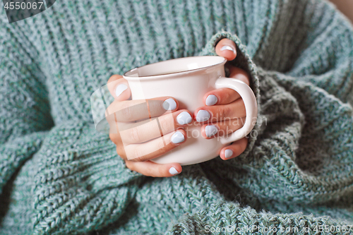 Image of Female hands holding hot cup of coffee or tea.