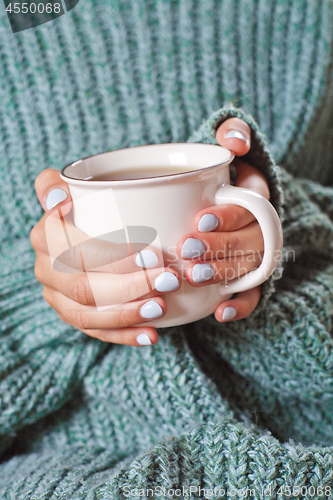 Image of Female hands holding hot cup of coffee or tea.