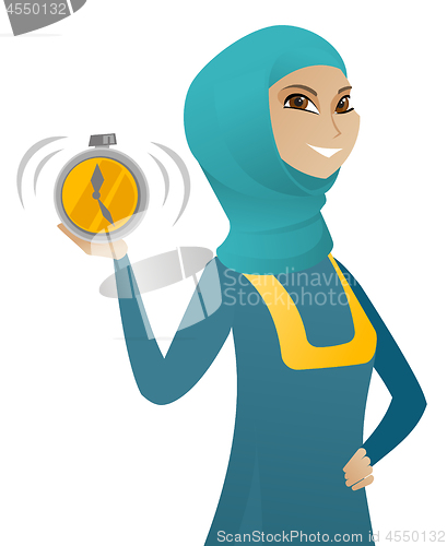 Image of Young muslim business woman holding alarm clock.
