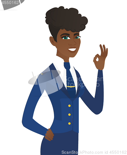 Image of Young african-american stewardess showing ok sign.