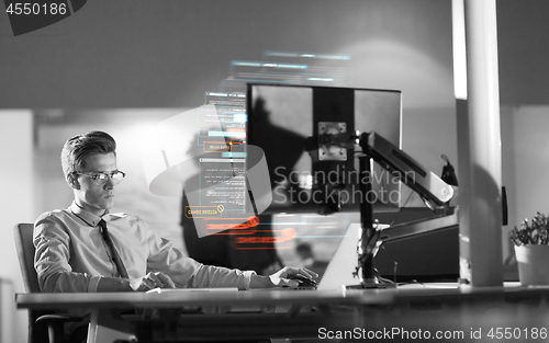 Image of man working on computer in dark office